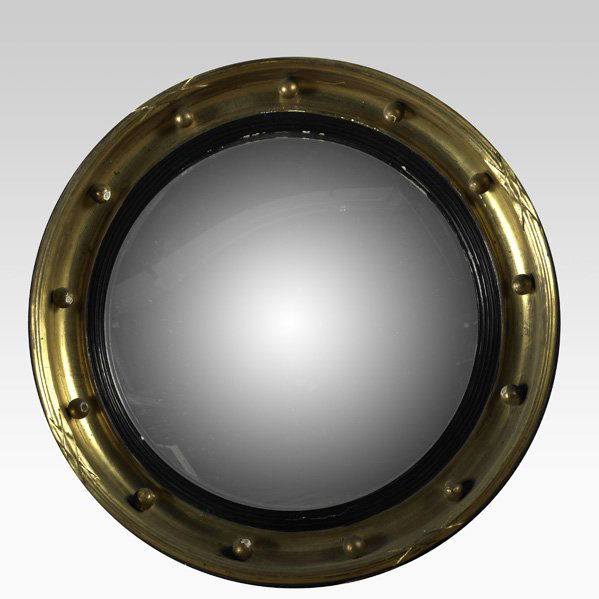 BULLSEYE MIRROR: BULLSEYE MIRROR; Convex glass in gilt frame with ebonized molding, 19th c.; 21 1/2'' dia.