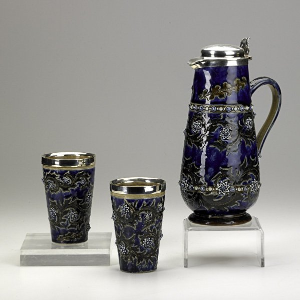 ROYAL DOULTON: ROYAL DOULTON; Silver-mounted presentation set comprised of covered tankard and two beakers, the tankard inscribed ''To Captain Peel from Duke of Connaught, 1877''; All with impressed mark/artist ciph