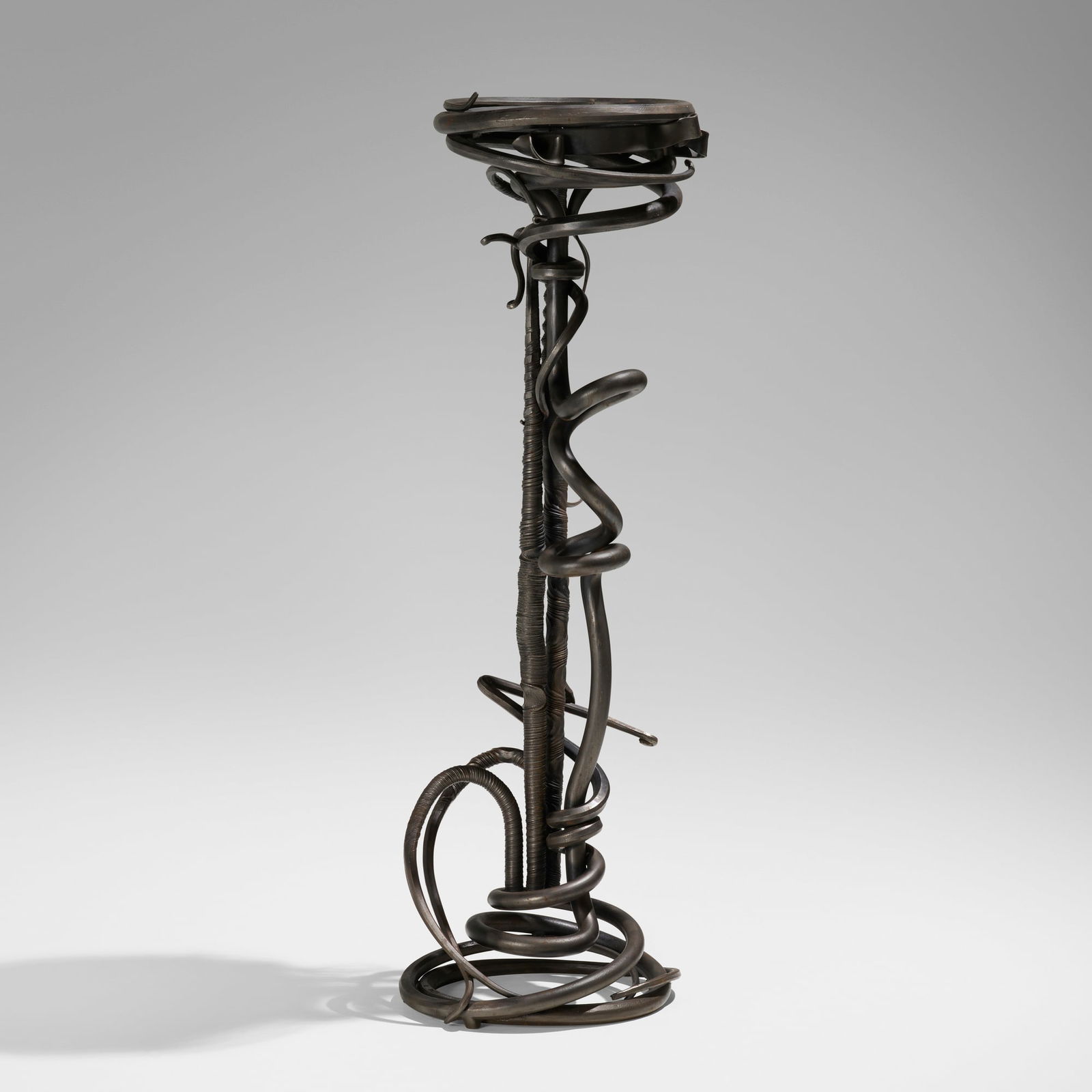 Albert Paley, Plant stand: Albert Paley Plant stand USA, 1988forged and fabricated steel with a blackened finish, slate 55 h x 16 dia in (140 x 41 cm) Incised signature and date to base '© Paley Studios LTD 1988'.