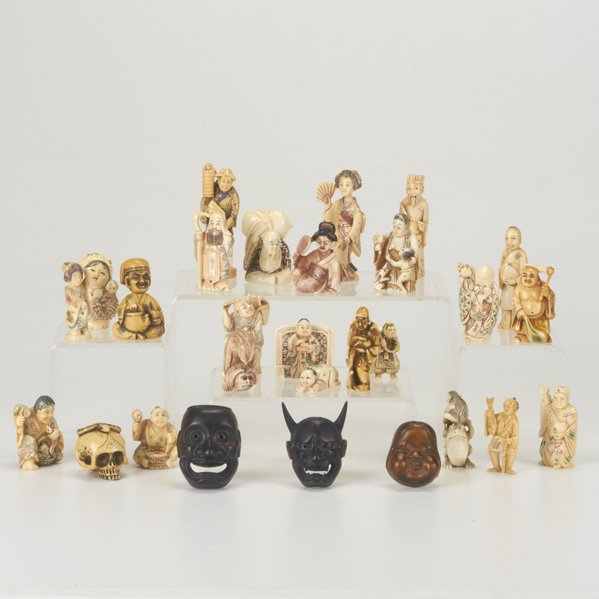 NETSUKES: Twenty-eight ivory or wood, 20th c,: ivory snake on a skull, ivory bird on a toad, three wood masks, etc; Most signed, Longest: 3"