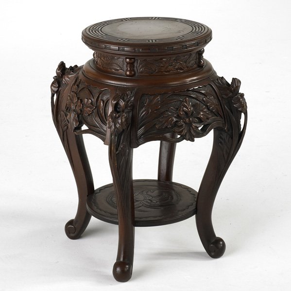 ASIAN LACQUERED TABOURET: Cinnabar color with carved foliate decoration, 20th c.; 24" x 20" dia.