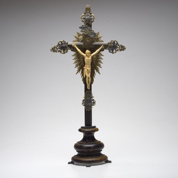 IVORY CRUCIFIX: On stand, European 19th/20th c; Carved ivory, German silver, and ebonized wood; Unmarked; Overall 24" x 11" x 3 1/2"