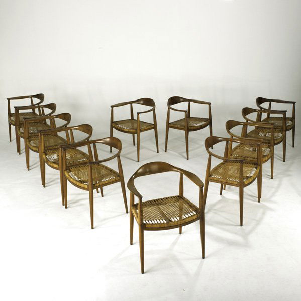 STYLE OF HANS WEGNER: Set of twelve dining chairs, Denmark, 1960s; Sculpted teak and woven cane; Unmarked; Each: 30" x 24 1/2" x 21"