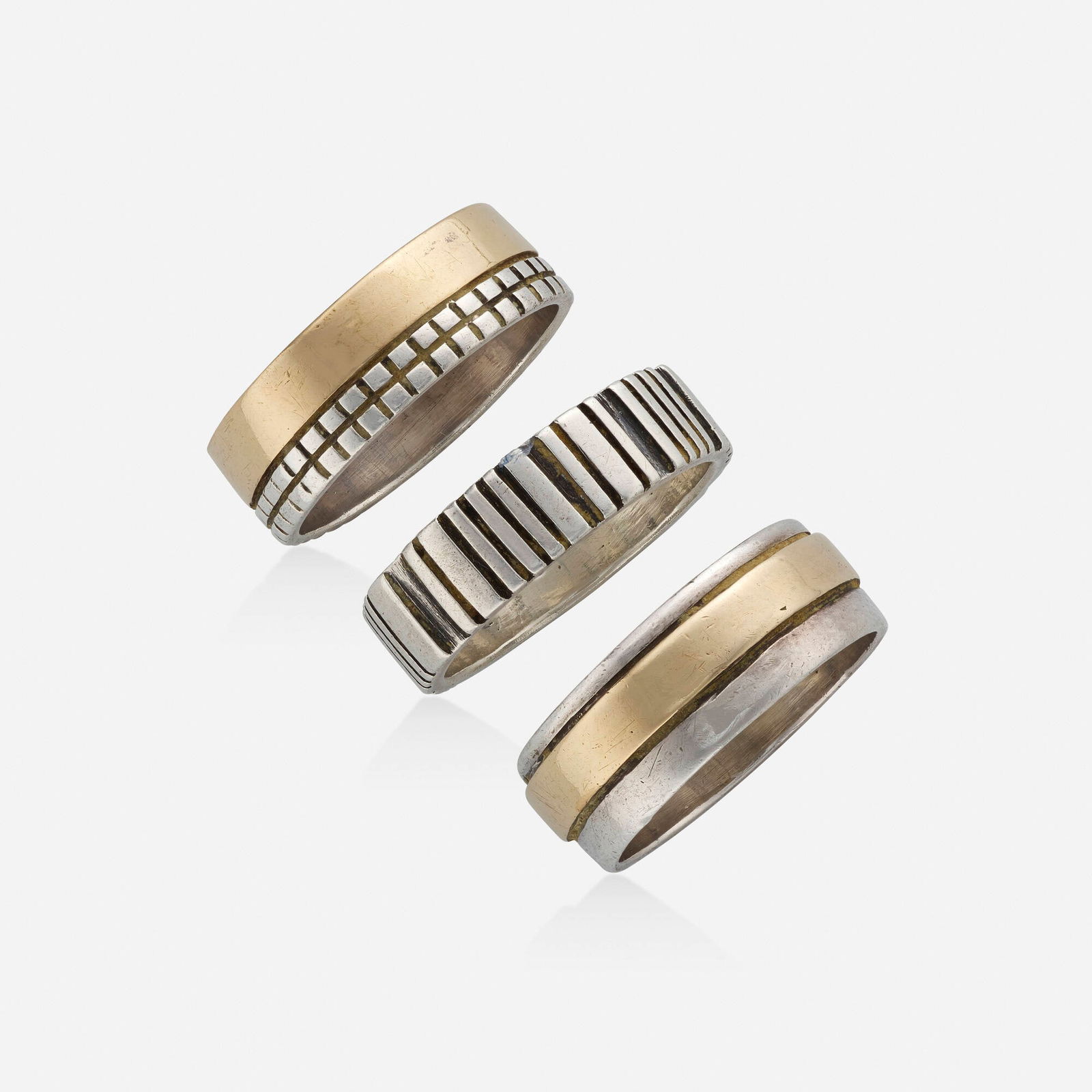 Margaret De Patta, Three sterling silver rings #16/17 and 18/19: Margaret De Patta Three sterling silver rings #16/17 and 18/19 Each of textured silver, two with bands of gold; 1947-57 Sterling silver and 14k yellow gold Signed de Patta to each Ring size 8.50; Gr