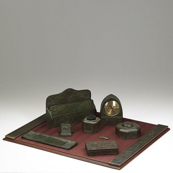 TIFFANY STUDIOS Desk set in Zodiac pattern: TIFFANY STUDIOS; Eight assembled desk set pieces in the Zodiac pattern, bronze patina, New York, NY: blotter ends, paper clip, pen tray, cigarette box, inkwell, pen wipe, clock and letter holder; Each