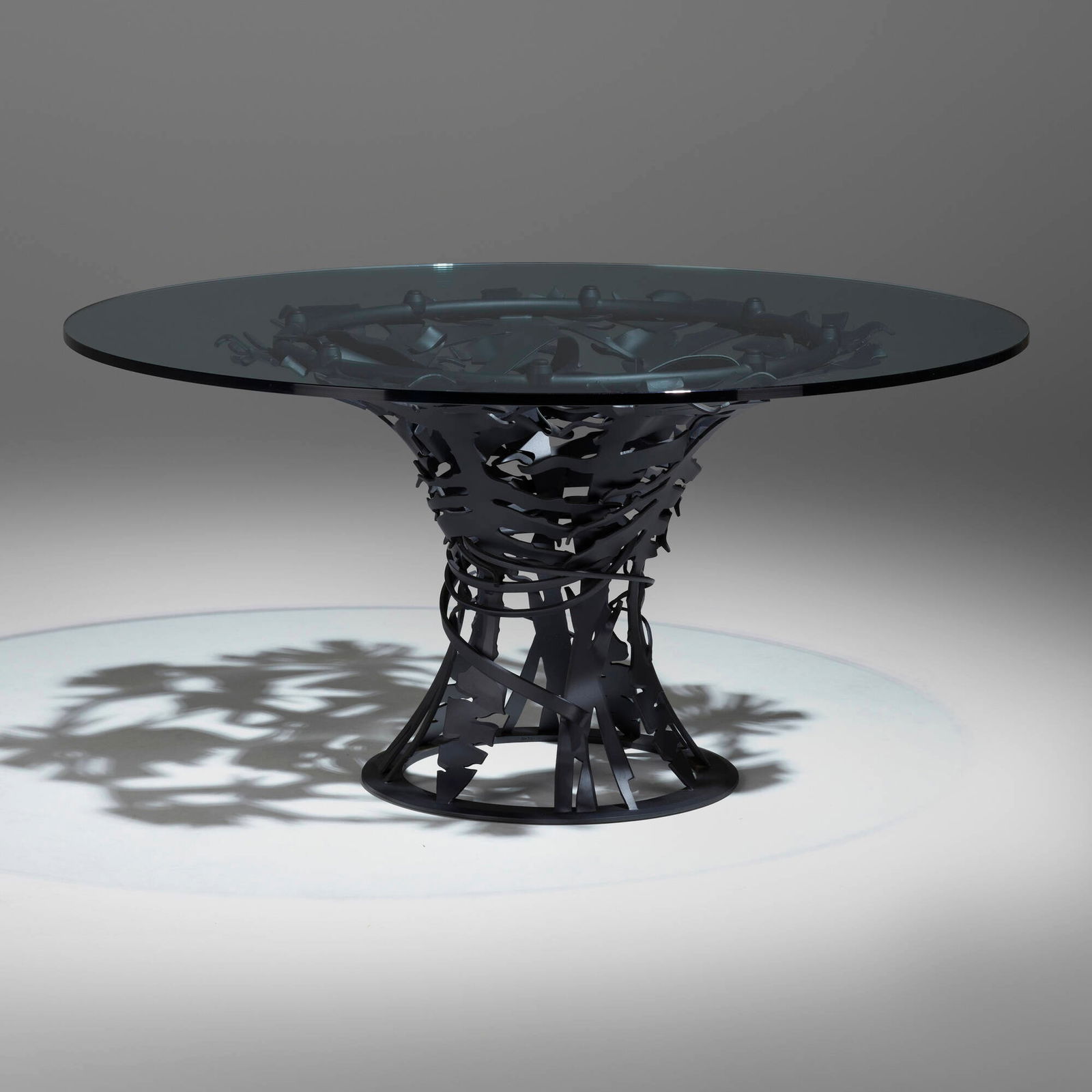 Albert Paley, Breakfast table: Albert Paley Breakfast table USA, 2006forged and fabricated steel with a blackened finish, glass 29.25 h x 60 dia in (74 x 152 cm) Impressed signature to base 'Albert Paley'. This work is from