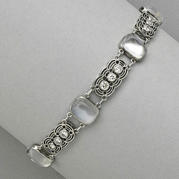 LOUIS COMFORT TIFFANY MOONSTONE BRACELET: Cushion-shaped moonstone cabochon links alternate with filigree diamond triplet links, platinum, ca. 1915. Marked Tiffany & Co. 11.5 dwt. (18 gs.), 7 1/2" x 3/8"