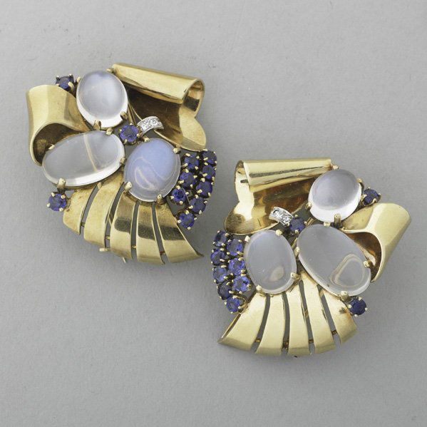 RAYMOND YARD MOONSTONE SAPPHIRE CLIPS: Mirror pair of clip brooches designed as volutes set with cabochon moonstones, faceted blue sapphires and diamond platinum accents, ca. 1943. Marked Yard, Inc., 14k. 19.8 dwt. (30.8 gs.), 1 3/4" x 1 3