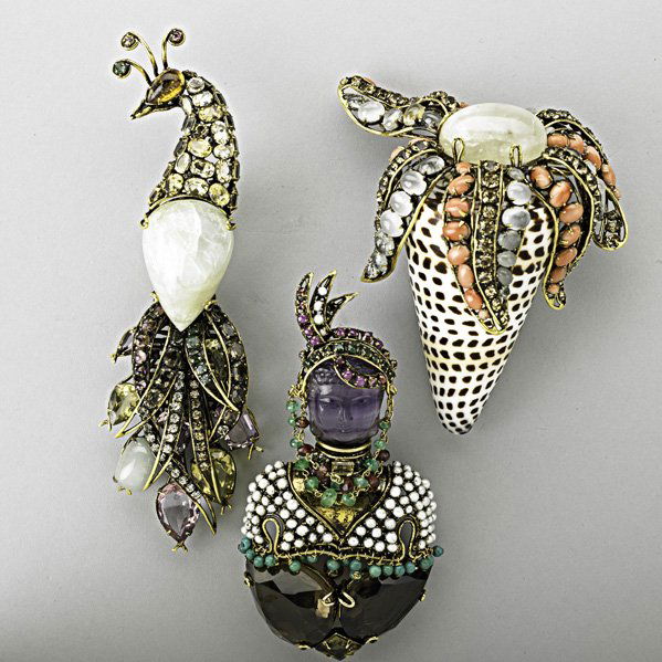 THREE IRADJ MOINI MASSIVE JEWELED BROOCHES, 20TH: Shell and starfish brooch in the style of Verdura with coral, quartz and rhinestones; peacock brooch with quartz, amethyst, rhinestone, emerald and citrine; blackamoor brooch with carved amethyst Budd