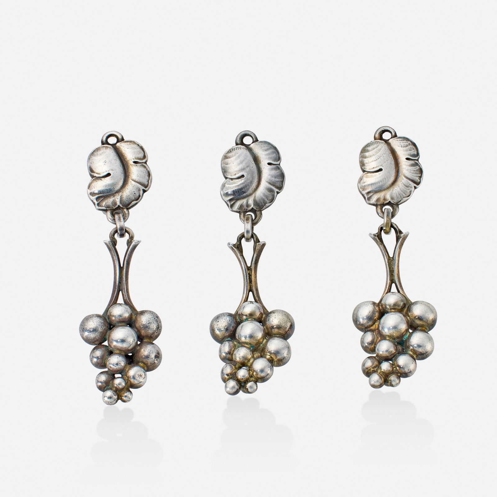 Georg Jensen, Three sterling silver earrings: Georg Jensen Three sterling silver earrings Comprising three earrings each depicting a cluster of grapes Sterling silver Signed with maker's mark for Georg Jensen to each example Each 2 x 0.50 i