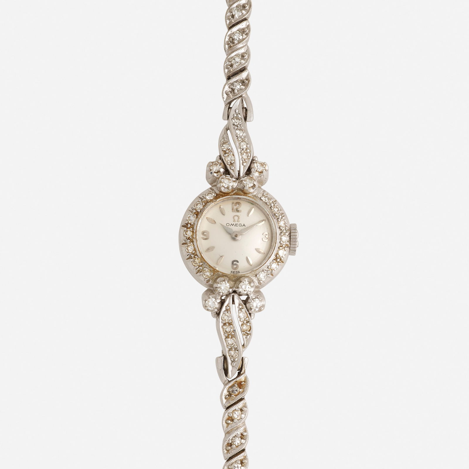 Omega, Diamond and white gold wristwatch: Omega Diamond and white gold wristwatch With applied dagger and Arabic numerals, and fancy link bracelet Dial: Silvered Movement: Manual wind Case material: 14k white gold Cas