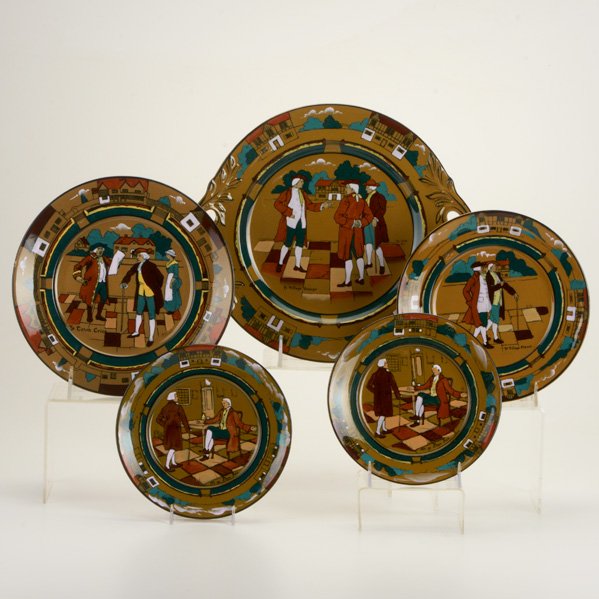 BUFFALO POTTERY: Deldare Ware, five plates: "Ye Village Gossips" cake plate, "Ye Town Crier," "Ye Village Street," and two "At Ye Lion Inn"; Marked; Cake plate: 11 1/4" x 10"