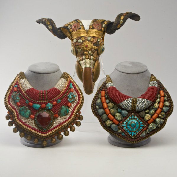 TIBETAN: Three pieces, 20th c.: two Ladakh gorgets set with carnelian, turquoise, coral and pearls; Rams skull decorated with various metals; Skull: 10" x 13"x 5"
