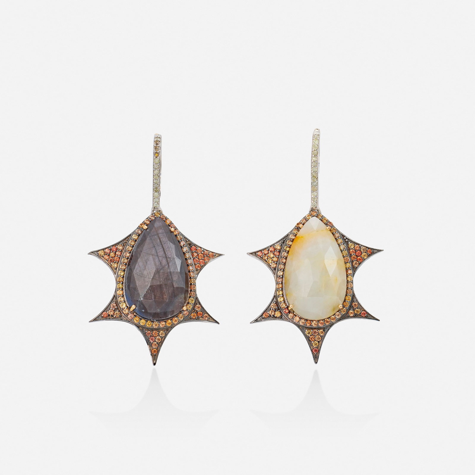 Multi-color sapphire, diamond, silver, and gold earrings: Multi-color sapphire, diamond, silver, and gold earrings Each set with a black or white pear-shaped sapphire, surrounded by circular-cut orange sapphires, the bail set with single-cut diamonds Silver 