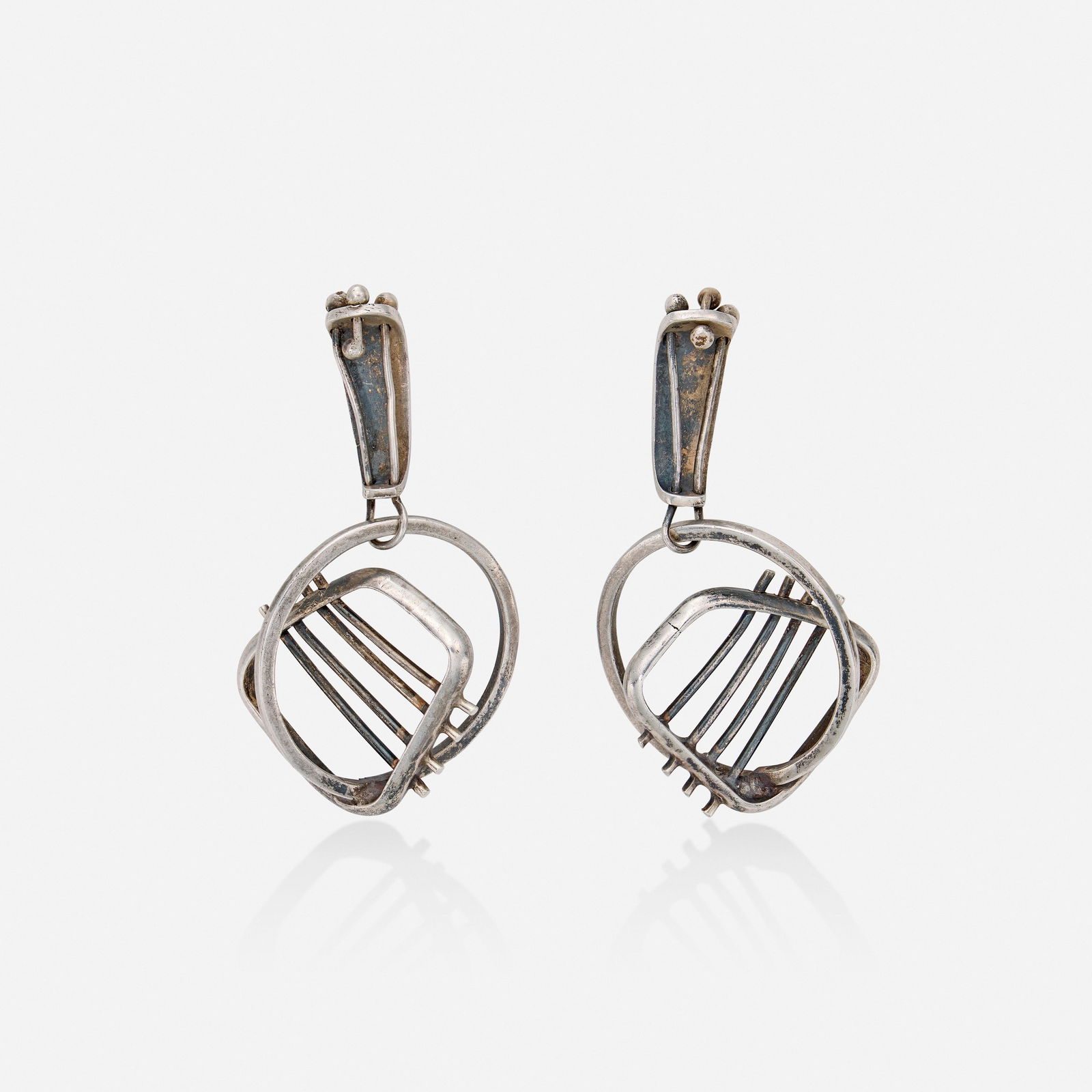 Ed Wiener, attribution, Silver earrings: Ed Wiener, attribution Silver earrings Of modernist design Silver 1.75 x 1 in; Gross weight 9.8 dwts This work will ship from Lambertville, New Jersey. Condition</