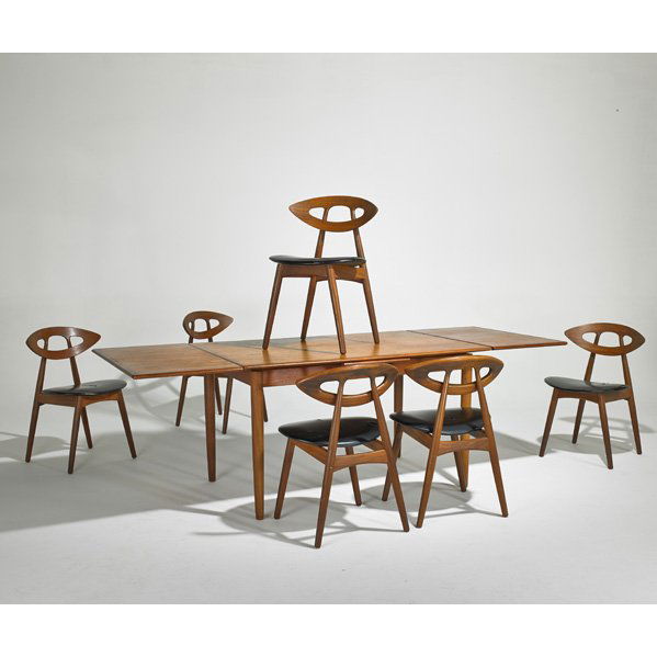 KURT OSTERVIG (Attr.): Extension dining table and six dining chairs, Denmark, 1960s; Sculpted teak and vinyl; Unmarked; Table open: 29" x 91" x 35", chairs: 30 1/2" x 20" x 18"