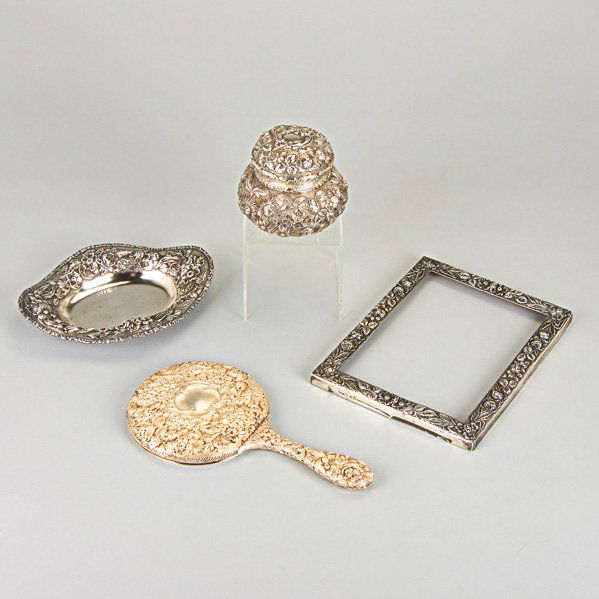 STIEFF STERLING VANITY ITEMS IN "BALTIMORE ROSE": Six items, 19th-20th c.: Round covered canister, monogrammed, 4"; Oval open tray, 8 1/4"; Picture frame, 9" x 7"; Hand mirror, 10"; Two rectangular trays, one marked for Howard & Co. and one marked fo