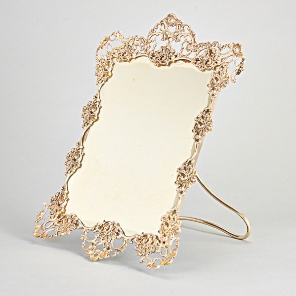 AMERICAN SILVER DRESSER MIRROR, MAUSER, ca. 1900: Rococo openwork castings, rectangular mirror with undulating bevel, silver easel-back with mahogany; 17 1/4" x 12"