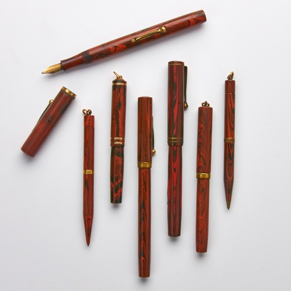 WAHL AND WATERMAN PENS OR PENCILS: Seven orange or red swirl hard rubber pens or pencils, Early 20th c.: Wahl Eversharp "Gregg" Redswirl; Two Waterman mechanical pencils; etc.; All marked; Longest: 5 1/4"