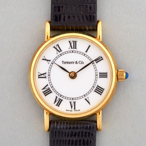 TIFFANY & CO. 14K GOLD LADIES WATCH, 1991: White face with Roman hours, sapphire crown, 29 mm, Swiss, original black lizard strap, presentational inscription on back of case
