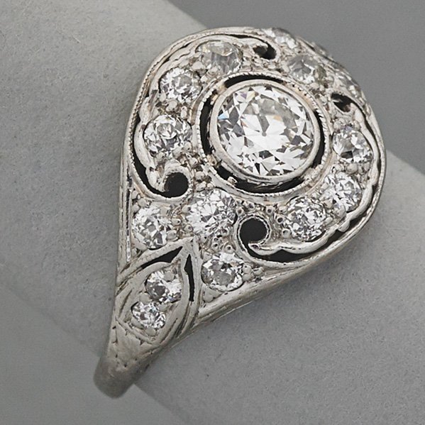 EDWARDIAN PLATINUM DIAMOND RING, ca. 1910: Pierced "cigar band", central OMC diamond, approx. .50 ct., and diamond accents approx. .65 ct. TW; 2.4 dwt., size 6, 13.26 mm., tapers