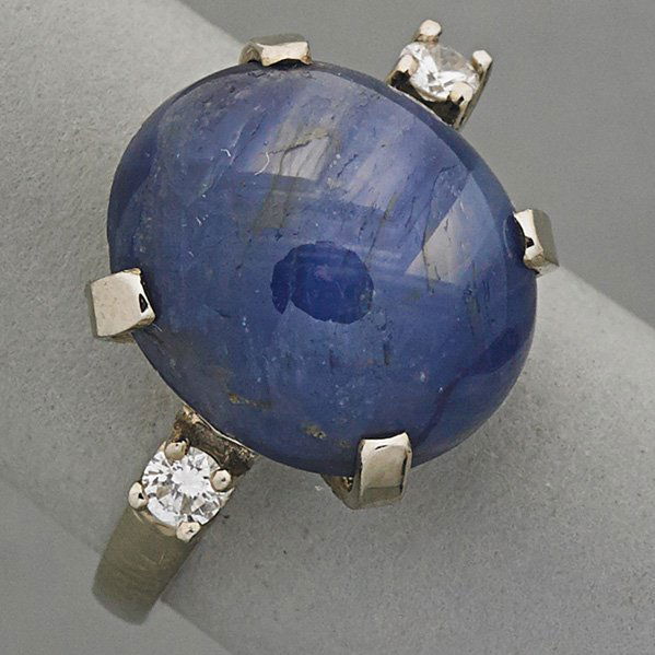 14K GOLD STAR SAPPHIRE AND DIAMOND RING, ca. 1960: Oval blue sapphire, 14.25 x 12.5 x 7.5 mm, approx. 12 cts., diamonds approx. .20 ct. TW in 14k wg.; 3.7 dwt., size 5 1/2
