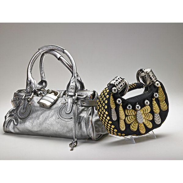 TWO CHLOE HANDBAGS: Black canvas metal hobo, 10" at widest point; Paddington silver leather padlock, 14" x 6" x 7"; Both with zip closures, dust bags