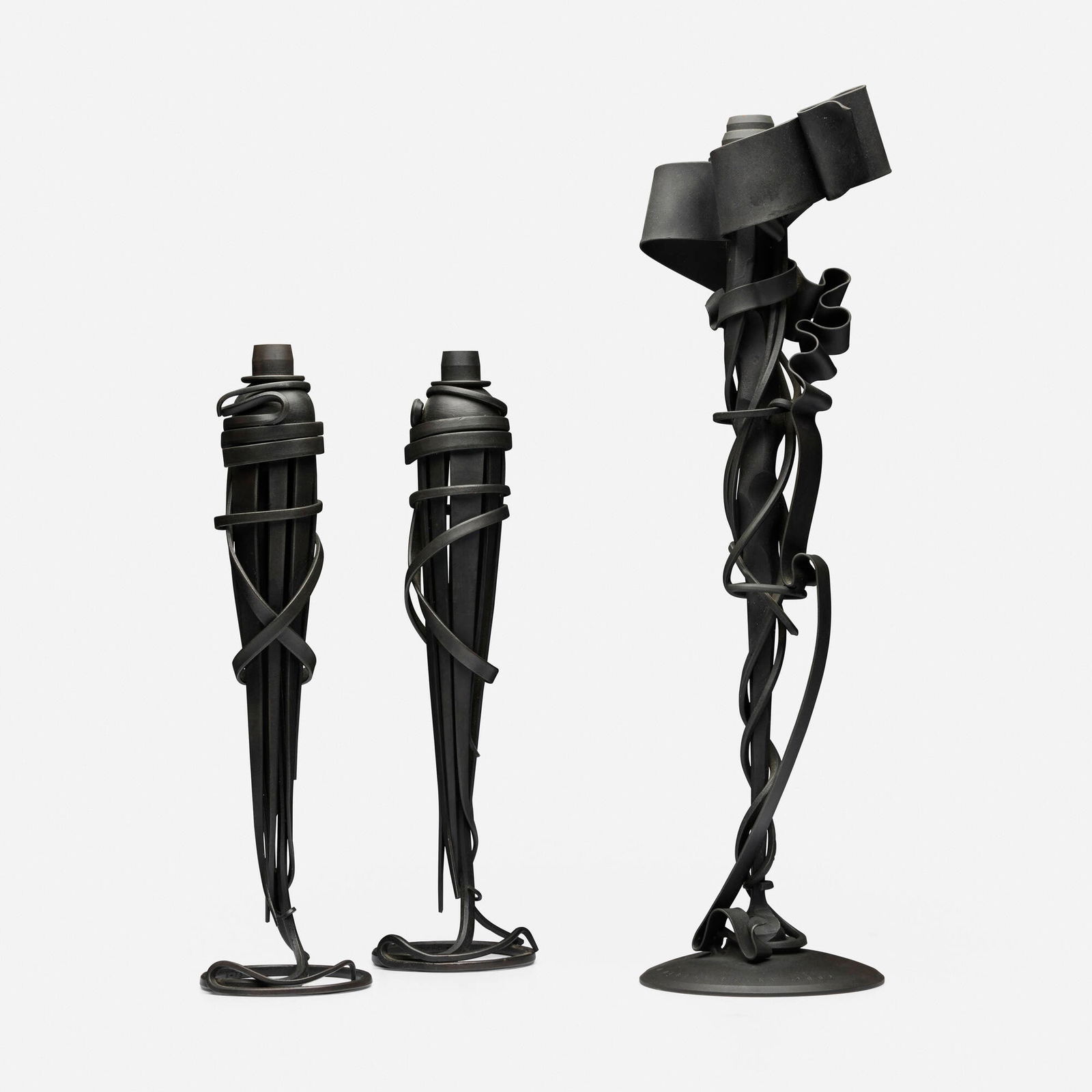 Albert Paley, Collection of three candleholders: Albert Paley Collection of three candleholders USA, 2001, 2002forged and fabricated steel with a blackened patina 21 h x 6 w x 4.5 d in (53 x 15 x 11 cm) 15.25 h x 4.25 dia in (39 x 11 cm)