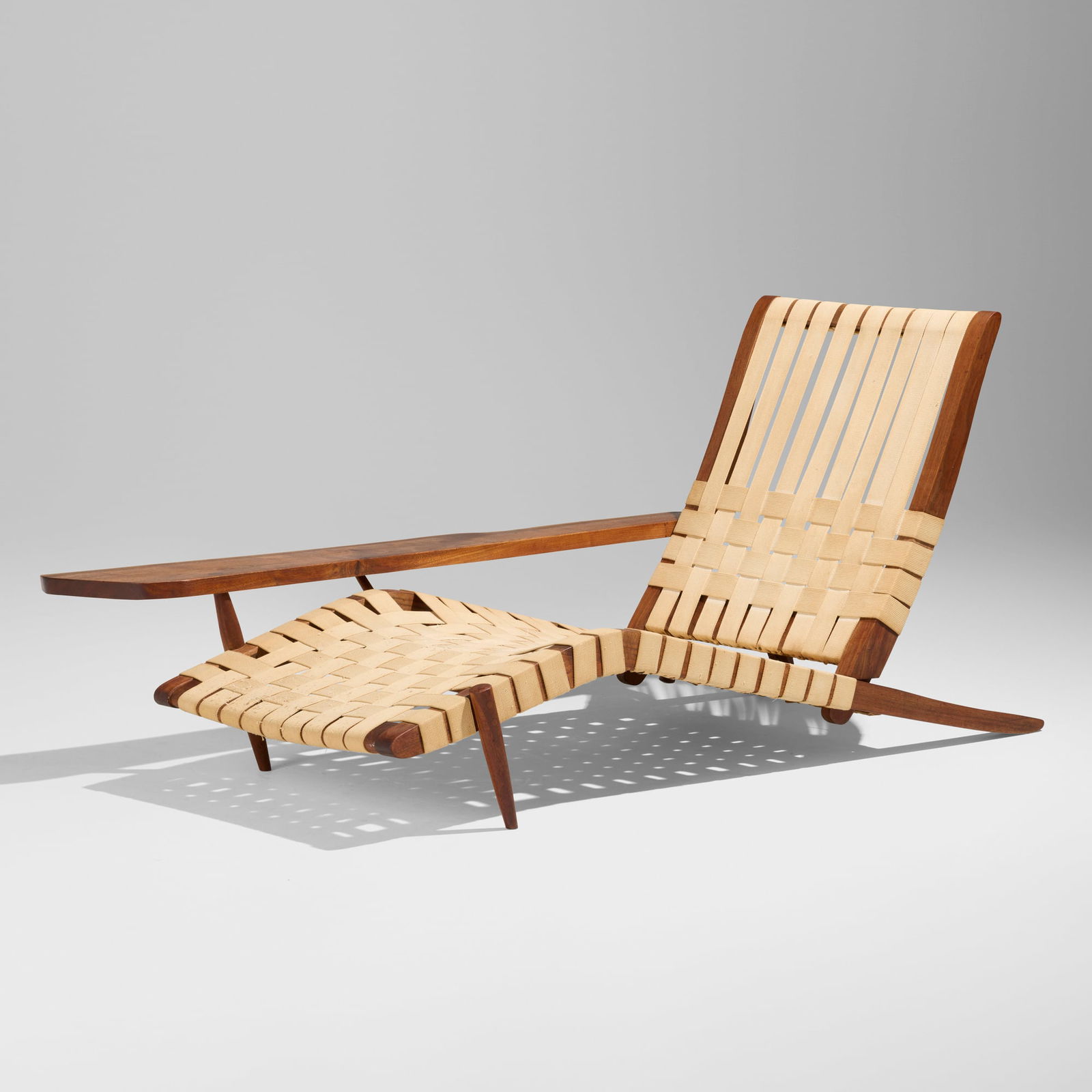 George Nakashima, Long Chair with Right Arm: George Nakashima Long Chair with Right Arm Nakashima StudioUSA, 1960American black walnut, canvas webbing 27.25 h x 36 w x 66.5 d in (69 x 91 x 169 cm) Chair features one free edge to th