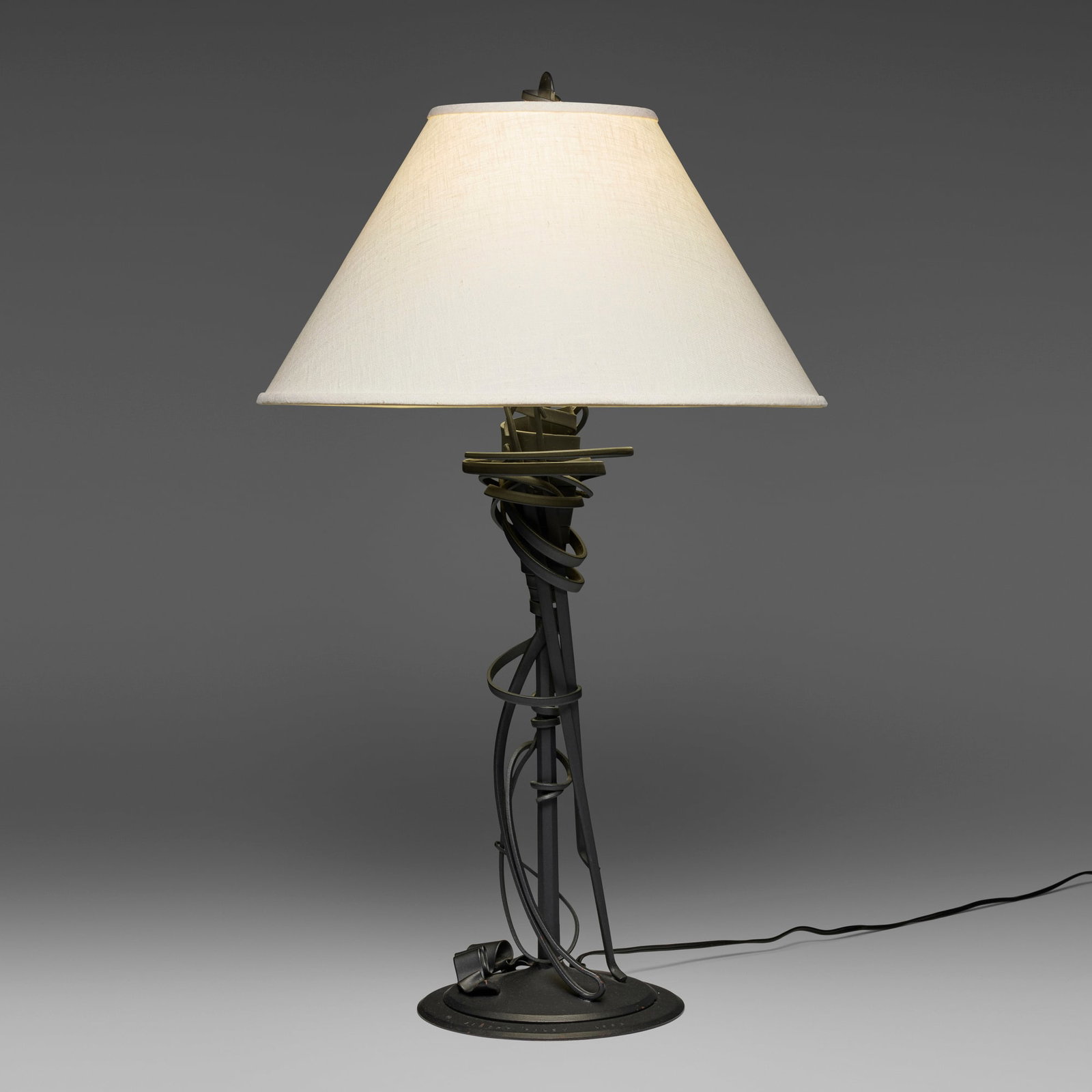 Albert Paley, Table lamp: Albert Paley Table lamp USA, 1993forged and fabricated steel with a blackened finish, linen shade 30.5 h x 18.25 dia in (77 x 46 cm) Impressed signature and date to top of base 'Albert Paley 1