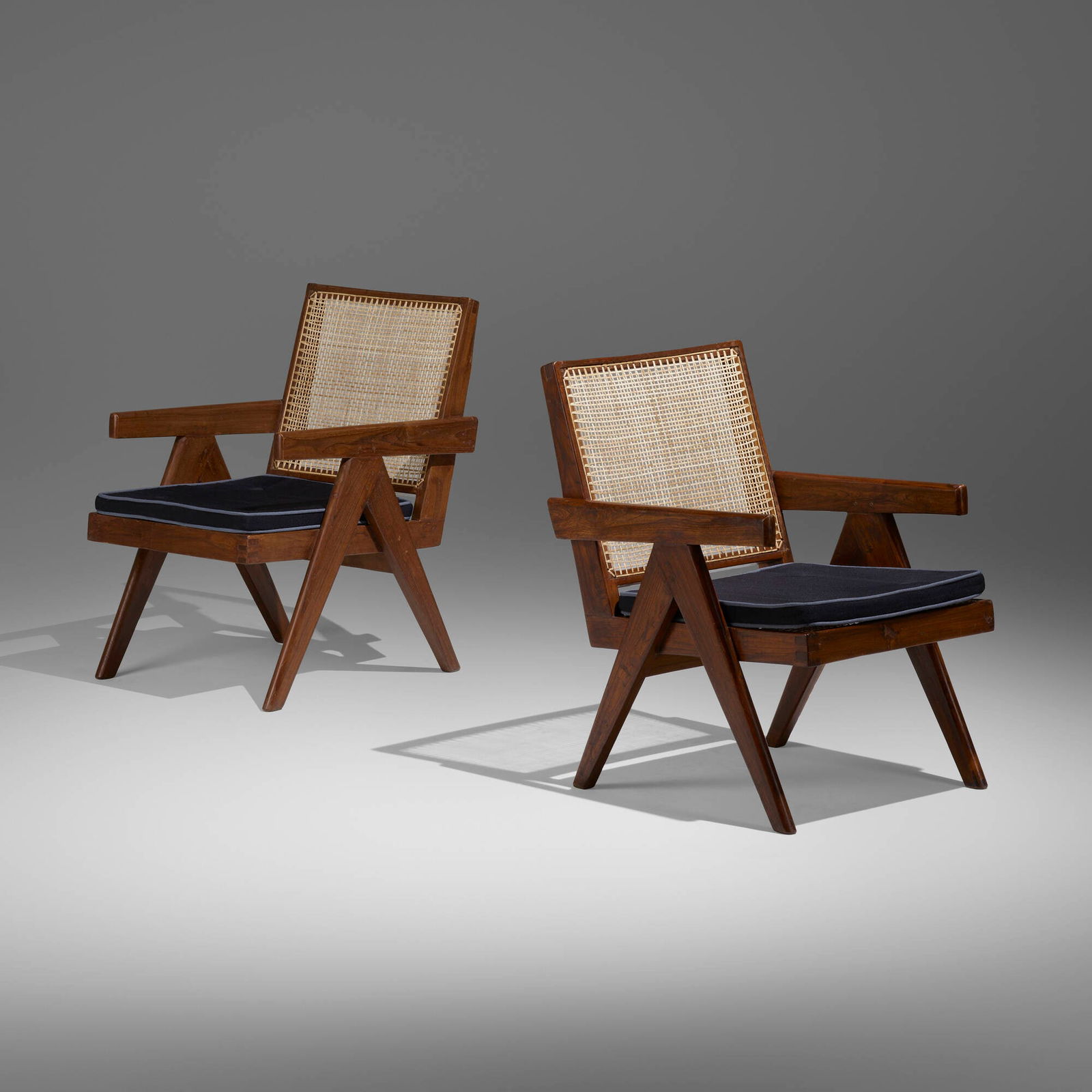 Pierre Jeanneret, Lounge chairs from the Punjab Engineering College, Chandigarh, pair: Pierre Jeanneret Lounge chairs from the Punjab Engineering College, Chandigarh, pair France/India, c. 1955teak, cane, upholstery 30.5 h x 21 w x 22 d in (77 x 53 x 56 cm) Provenance:</