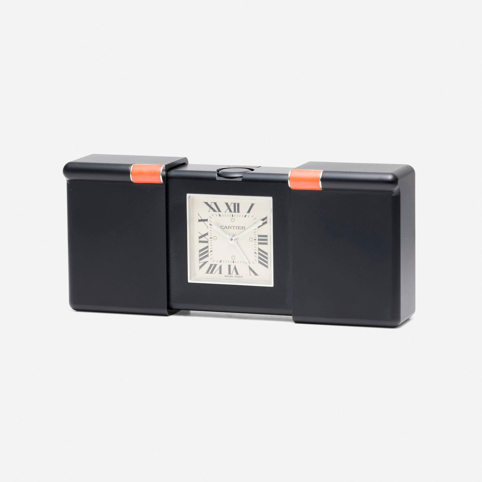Cartier, Black Teflon and coral travel clock: Cartier Black Teflon and coral travel clock With Roman numeral hours Dial: White Movement: Quartz Case material: Black Teflon and cabochon coral Case size: 60 x 41 mm S