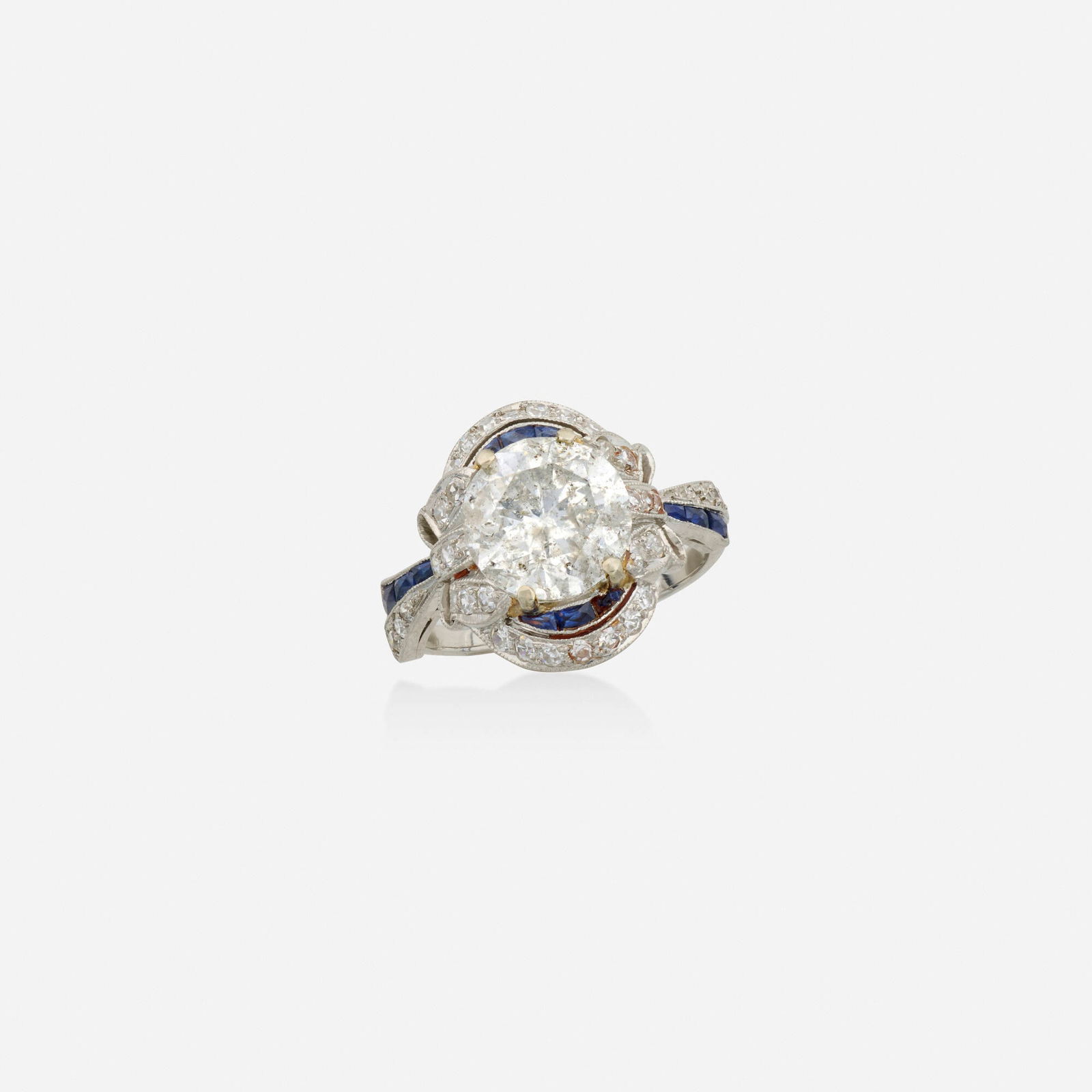Art Deco, Diamond, sapphire, and platinum ring: Art Deco Diamond, sapphire, and platinum ring Set with a round brilliant-cut diamond, with calibre-cut sapphire and single-cut diamond bows Platinum Ring size 4.75; Gross weight 2.9 dwts