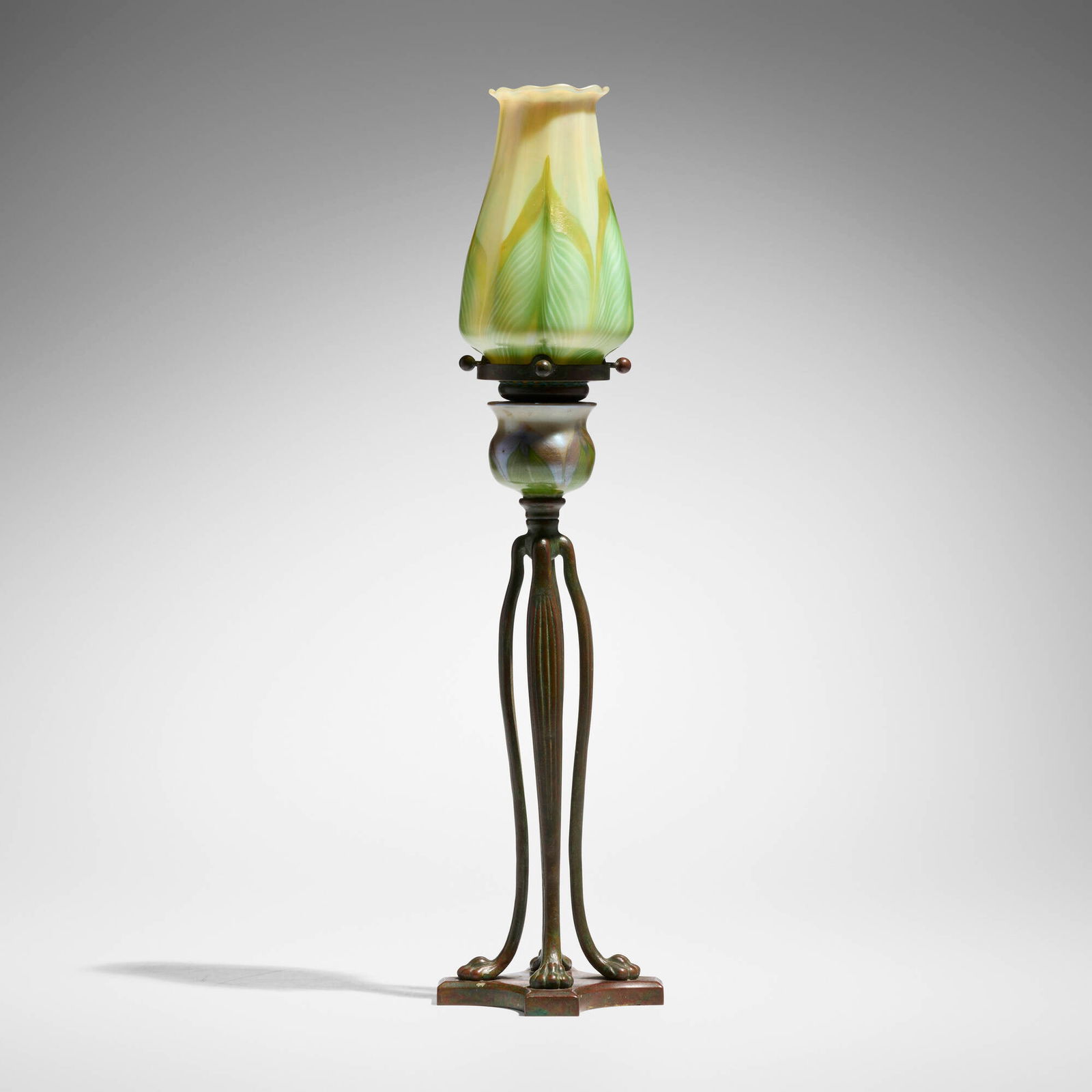 Tiffany Studios, Early Cat's Paw candlestick with pulled-feather shade and cup: Tiffany Studios Early Cat's Paw candlestick with pulled-feather shade and cup USA, c. 1900 patinated bronze, hand-blown Favrile glass 16.25 h x 4 dia in (41 x 10 cm) Etched to shade 'L.C.T.