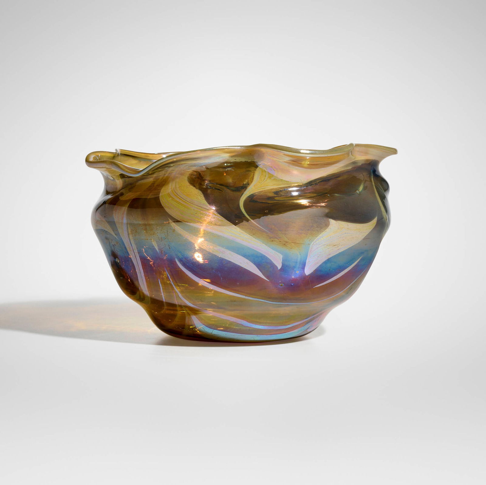 Tiffany Studios, Early decorated reactive bowl: Tiffany Studios Early decorated reactive bowl USA, c. 1892-93 hand-blown Favrile glass 6.75 h x 10.75 dia in (17 x 27 cm) Etched to underside '5558 L.C.T.'. Provenance: Lillian Nassau, New York |