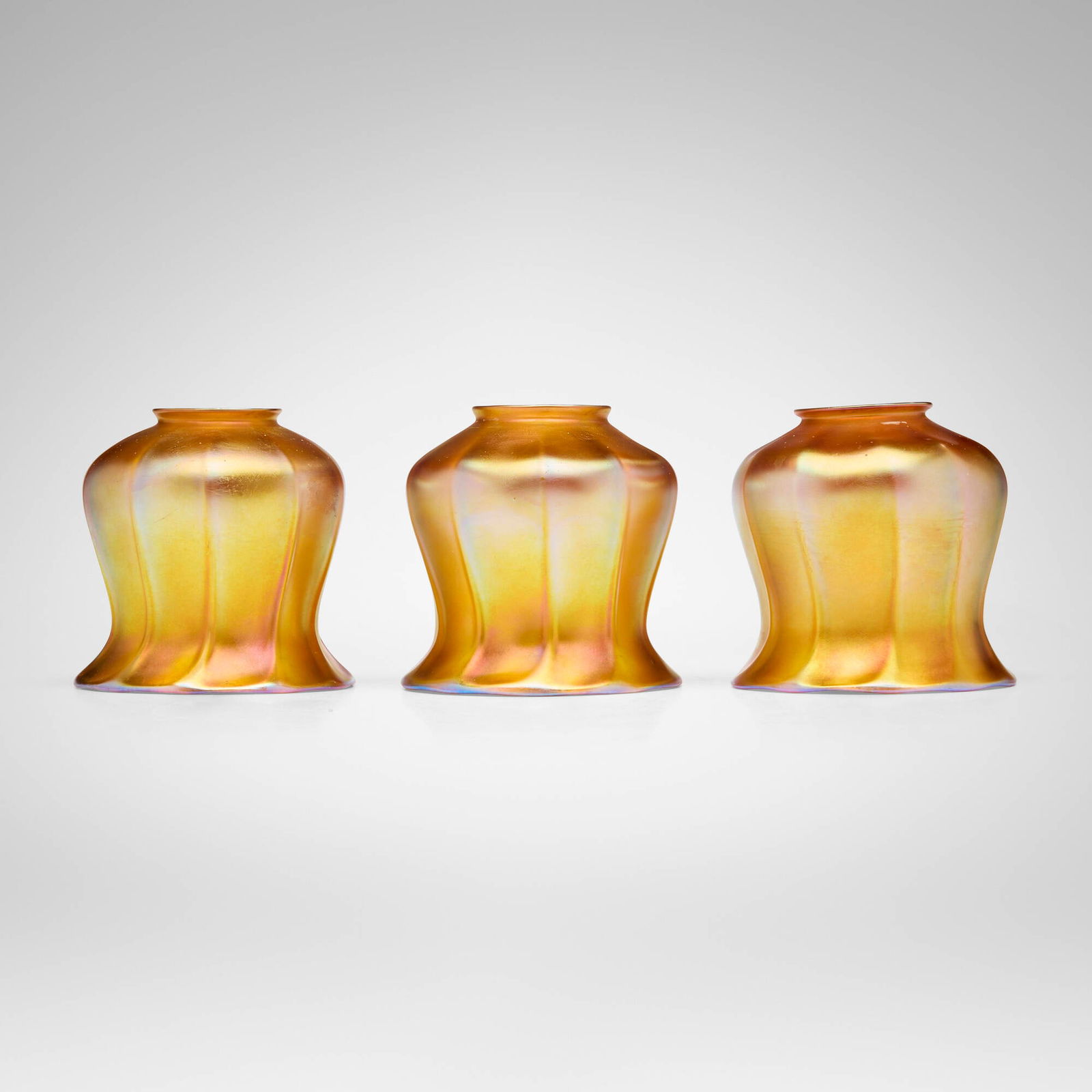 Quezal, Ribbed shades, set of three: Quezal Ribbed shades, set of three USA, c. 1910 hand-blown glass 4.5 h x 4.5 dia in (11 x 11 cm) Etched manufacturer's mark to each shade 'Quezal'. This work will ship from Lambertville, New