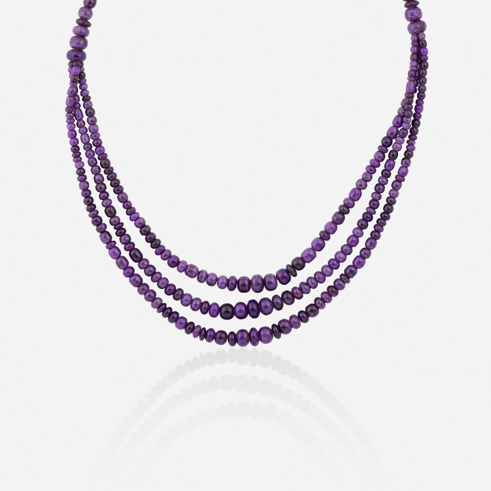 Sugilite and gold necklace: Sugilite and gold necklace Designed with three strands of graduated sugilite beads Yellow gold 18.25 in; Gross weight 26.2 dwts This work will ship from Lambertville, New Jersey.