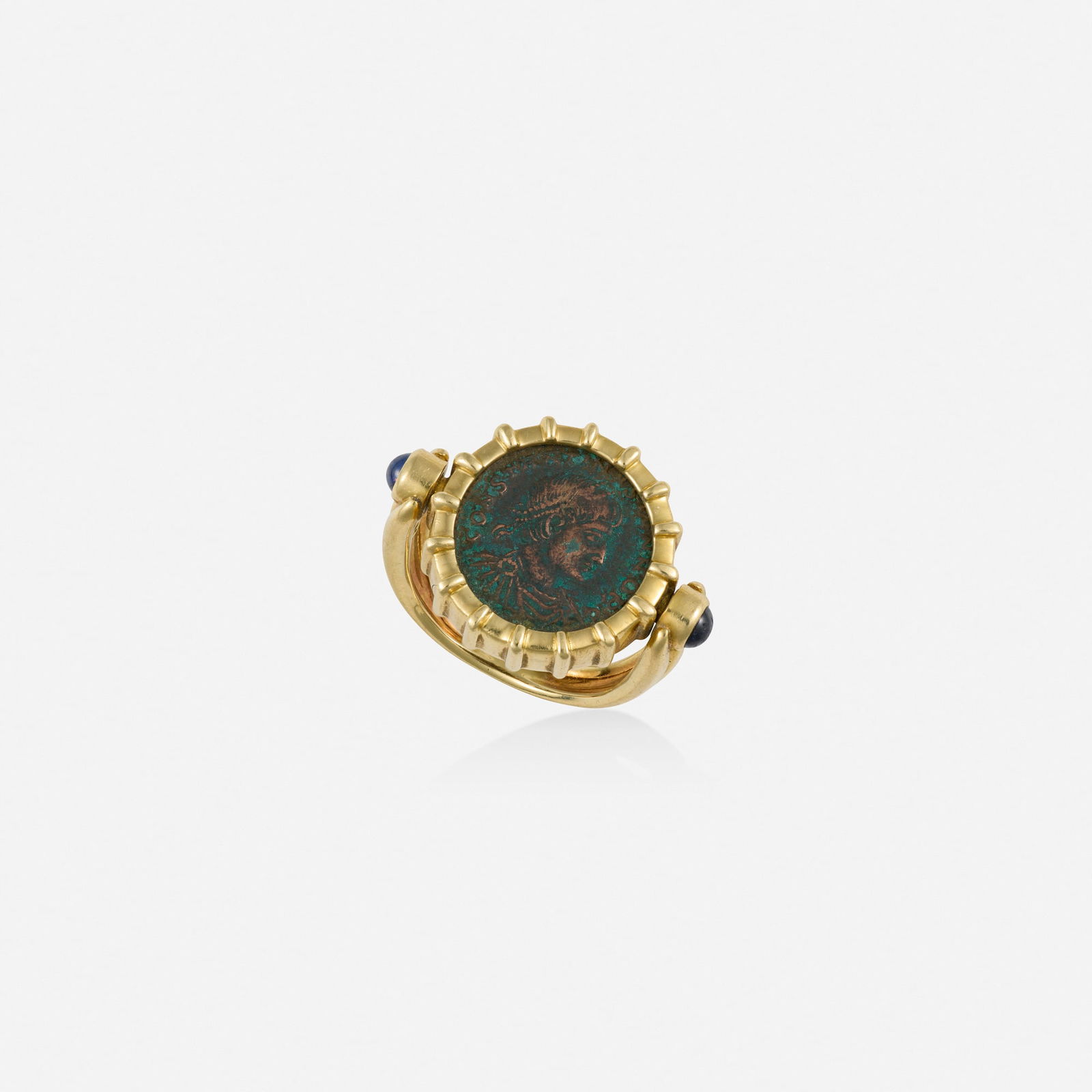 Coin, sapphire, and gold ring: Coin, sapphire, and gold ring Set with Roman bronze coin and cabochon sapphire terminals 18k yellow gold Ring size 7-8; Gross weight 6.8 dwts This work will ship from Lambertville, New Jersey.