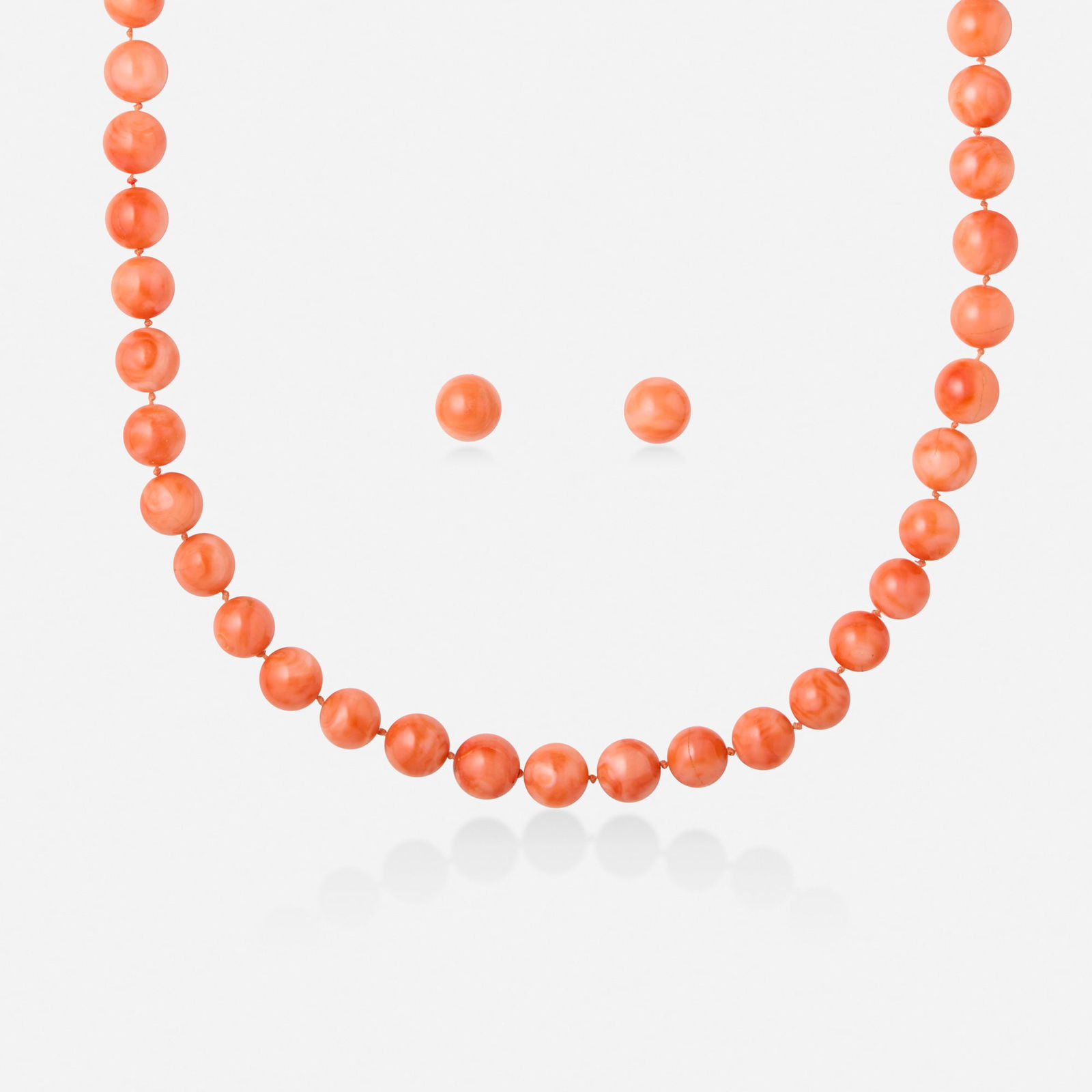 Coral necklace and earrings: Coral necklace and earrings The necklace strung with coral beads, joined by a round gold clasp, the earrings each a coral bead Yellow gold Necklace 26 in, earrings 0.375 in; Gross weight 62.4 dwts 