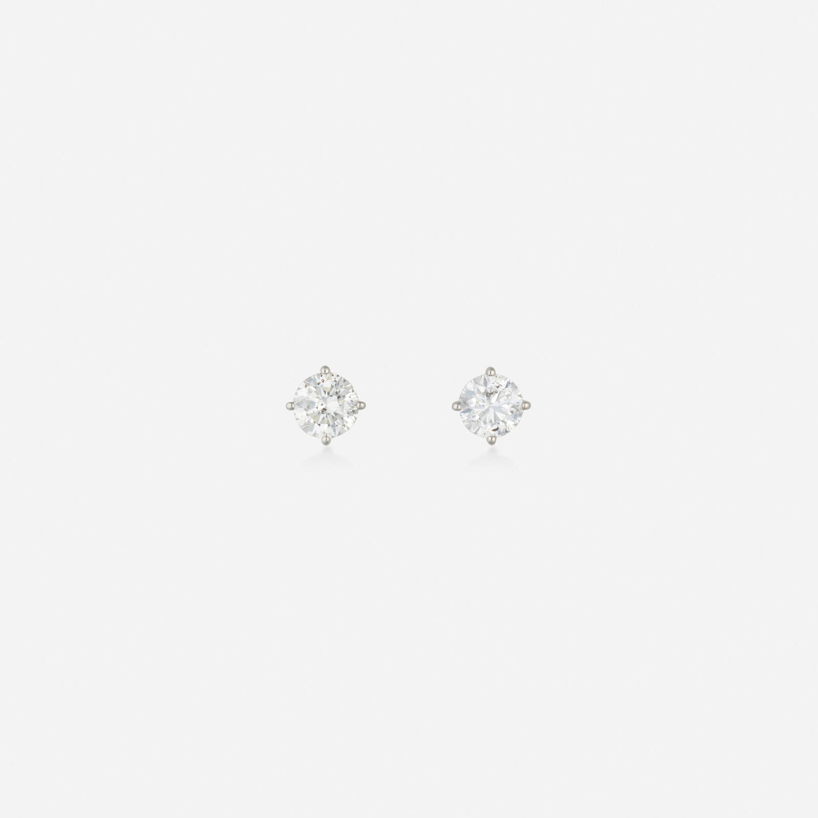 Diamond and white gold earrings: Diamond and white gold earrings Each set with a round brilliant-cut diamond White gold 0.25 in; Gross weight 0.6 dwts This work will ship from Lambertville, New Jersey.