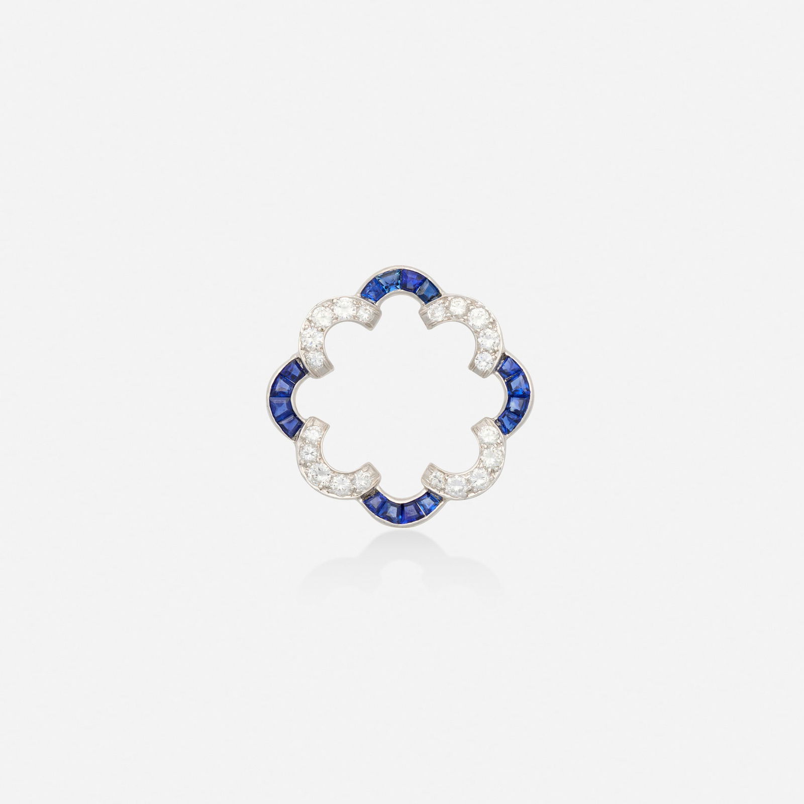 Sapphire, diamond, and platinum brooch: Sapphire, diamond, and platinum brooch Of scalloped design, set with calibre-cut sapphires and round brilliant-cut diamonds Platinum 1.25 in; Gross weight 3.7 dwts This work will ship from