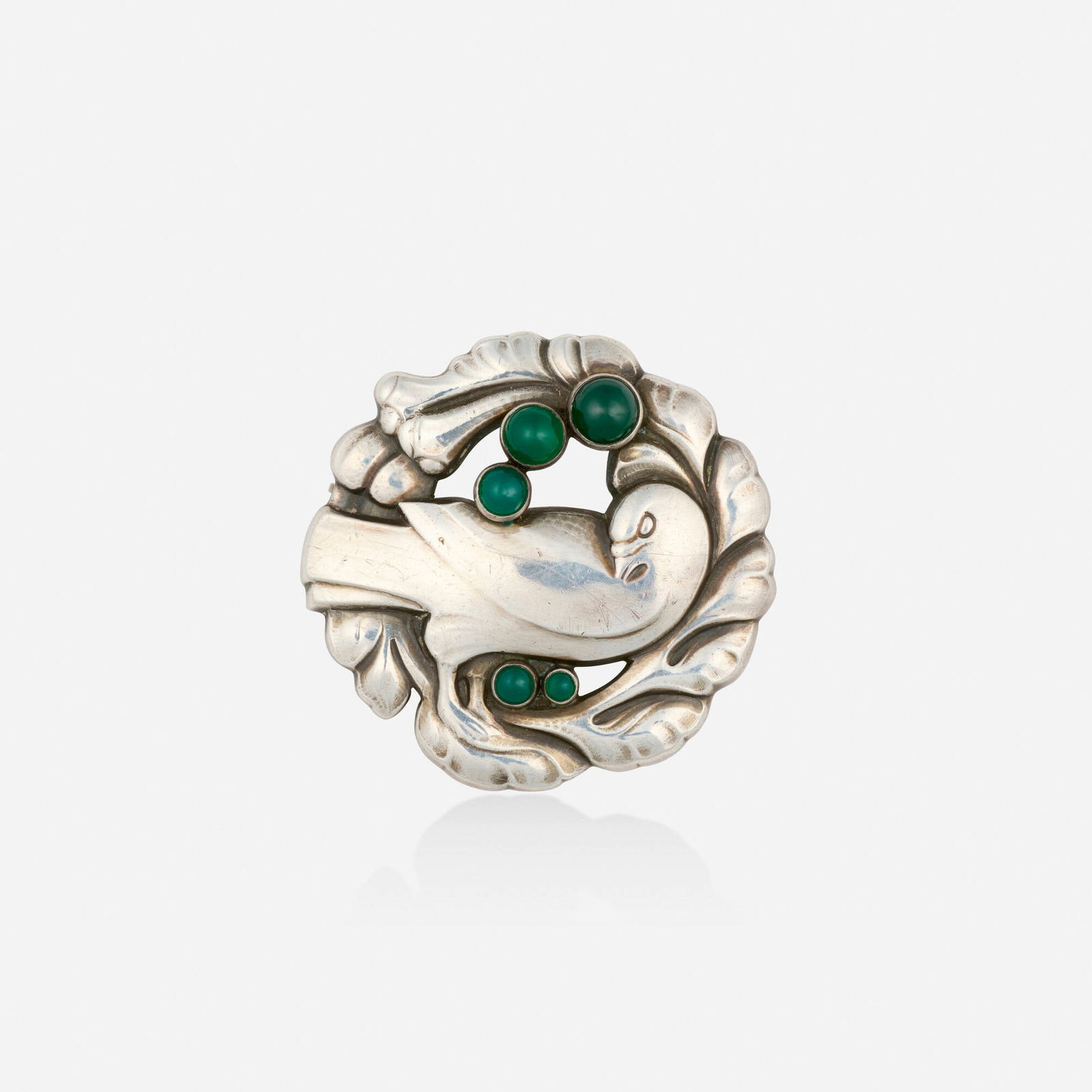 Georg Jensen, Green chalcedony and sterling silver brooch: Georg Jensen Green chalcedony and sterling silver brooch Depicting a framed dove, set with cabochon green chalcedony, no. 123; designed by Kristian Mohl-Hansen Sterling silver Signed with maker's mark