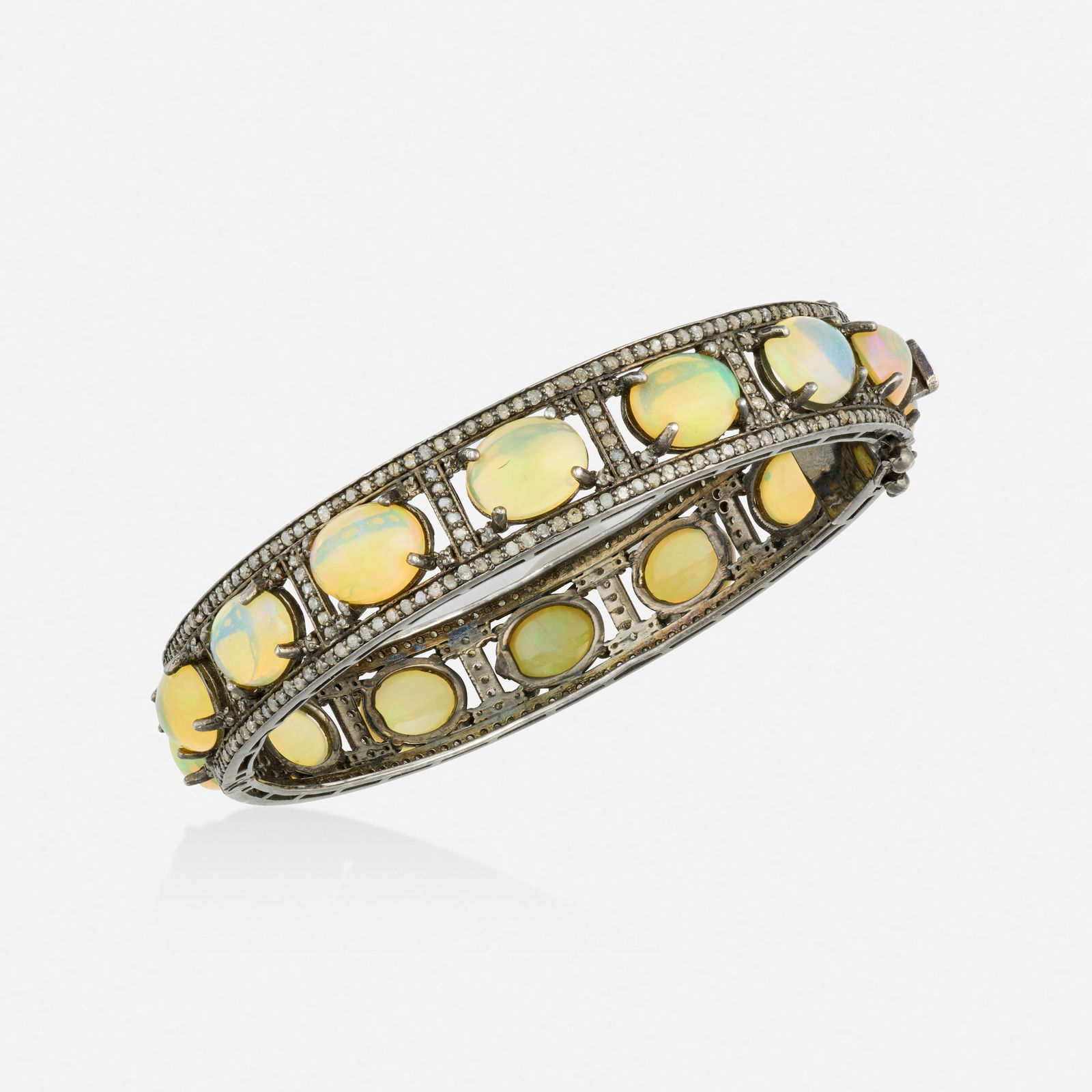 Opal, diamond, and silver bracelet: Opal, diamond, and silver bracelet The hinged bangle set with cabochon opals and single-cut diamonds Silver Inner circ. 7.50 in, width 0.50 in; Gross weight 18.9 dwts This work will ship from