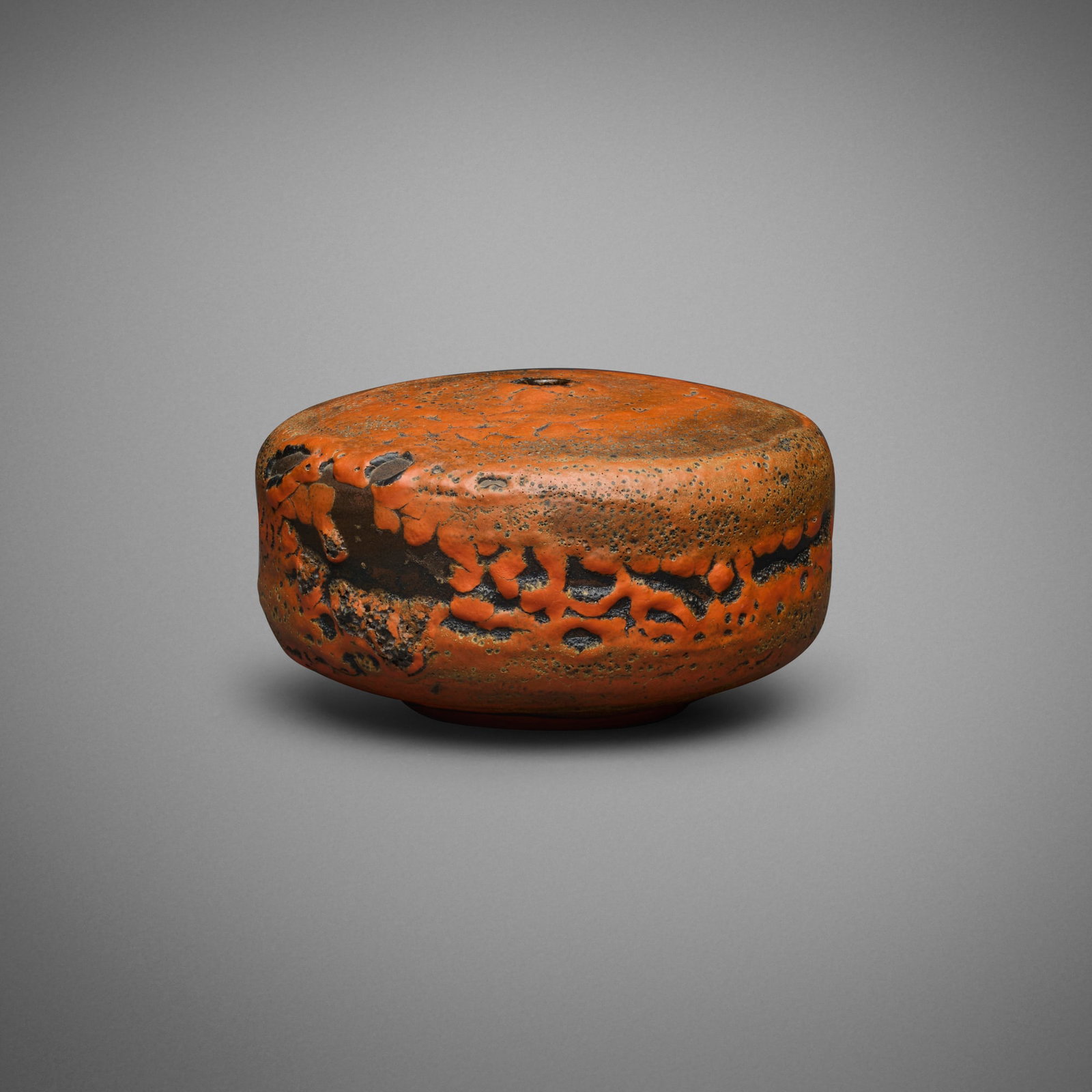 Gertrud and Otto Natzler, Squat cylindrical bottle: Gertrud and Otto Natzler Squat cylindrical bottle 1968 earthenware with Orange Red Crater glaze 3.5 h x 6.25 dia in (9 x 16 cm) Signed to underside 'Natzler' with archive number 'O139'