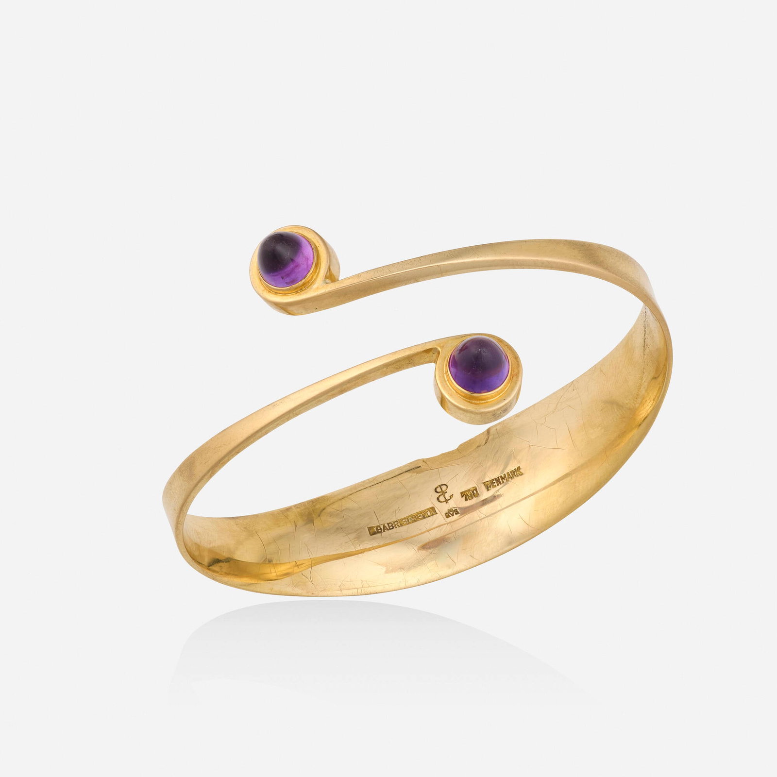 Bent Gabrielsen, Amethyst and gold bracelet: Bent Gabrielsen Amethyst and gold bracelet The bangle of crossover design, set with cabochon amethysts 18k yellow gold Signed B. Gabrielsen Inner circ. 7.50 in, width 1.25 in; Gross weight 21.9 dwts