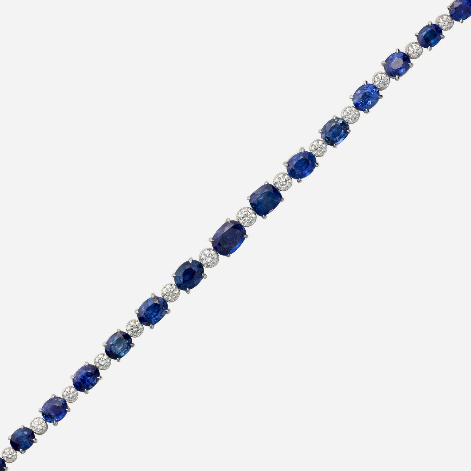 Sapphire, diamond, and white gold bracelet: Sapphire, diamond, and white gold bracelet Set with alternating oval-cut sapphires and round brilliant-cut diamonds 18k white gold 7.50 x 0.25 in; Gross weight 12.8 dwts This work will ship from