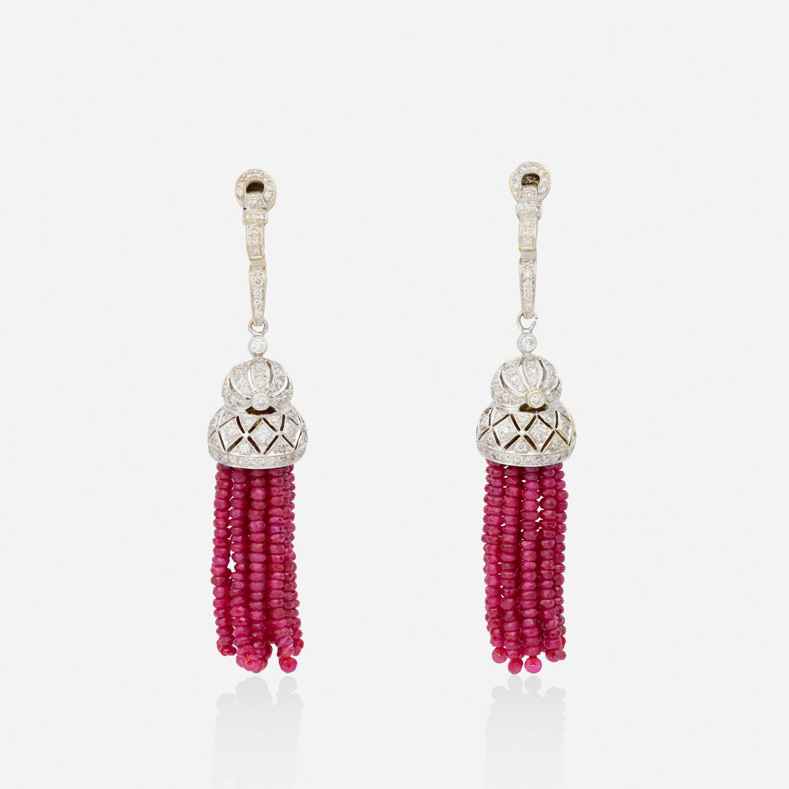 Ruby, diamond, and white gold earrings: Ruby, diamond, and white gold earrings Each a tassel set with round brilliant-cut diamonds and ruby beads 18k yellow gold-plated white gold 2.75 x 0.50 in; Gross weight 15.3 dwts This work will ship