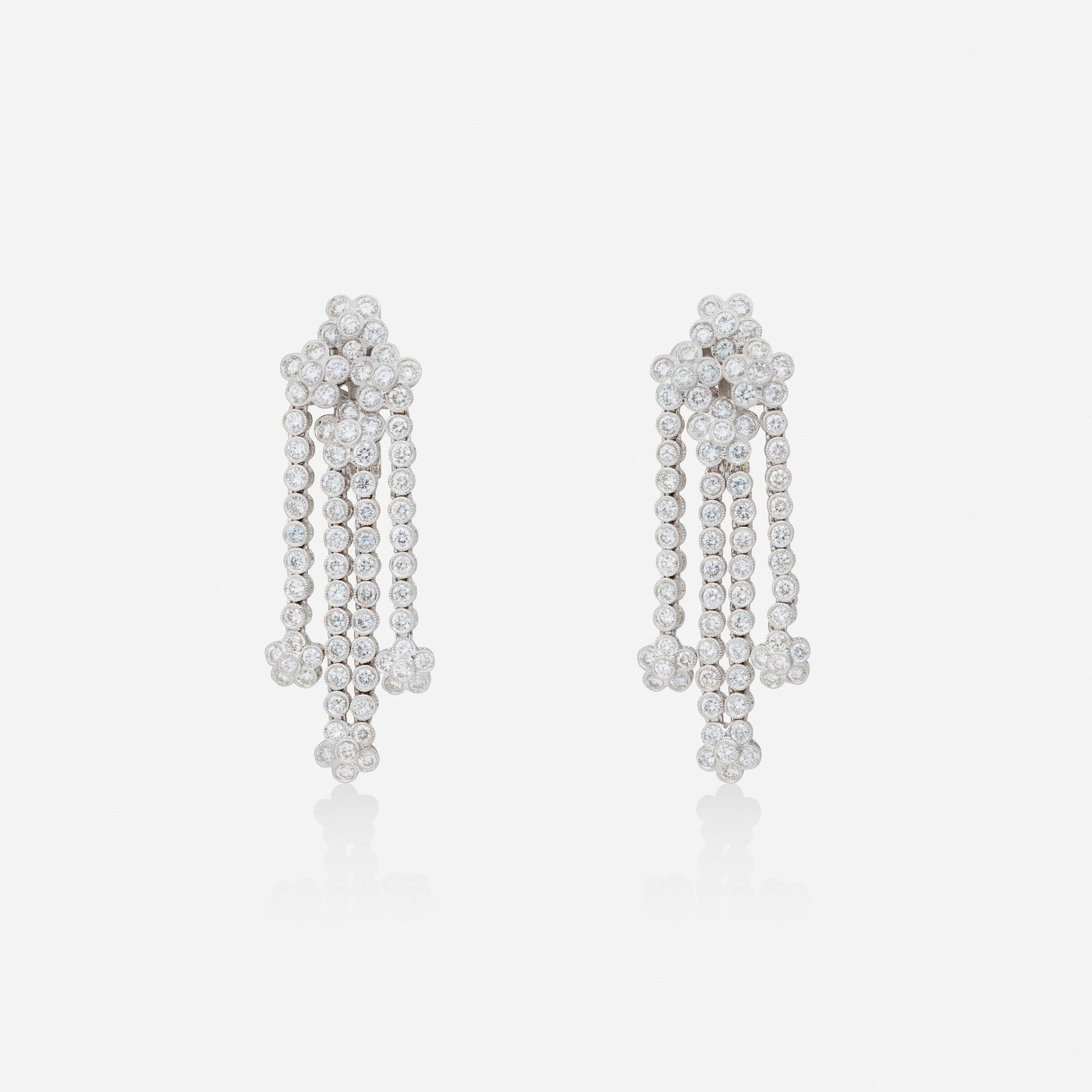 Diamond and white gold earrings: Diamond and white gold earrings Each of cascading floral design, set with round brilliant-cut diamonds 18k white gold 1.875 x 0.625 in; Gross weight 13.4 dwts This work will ship from Lambertville,