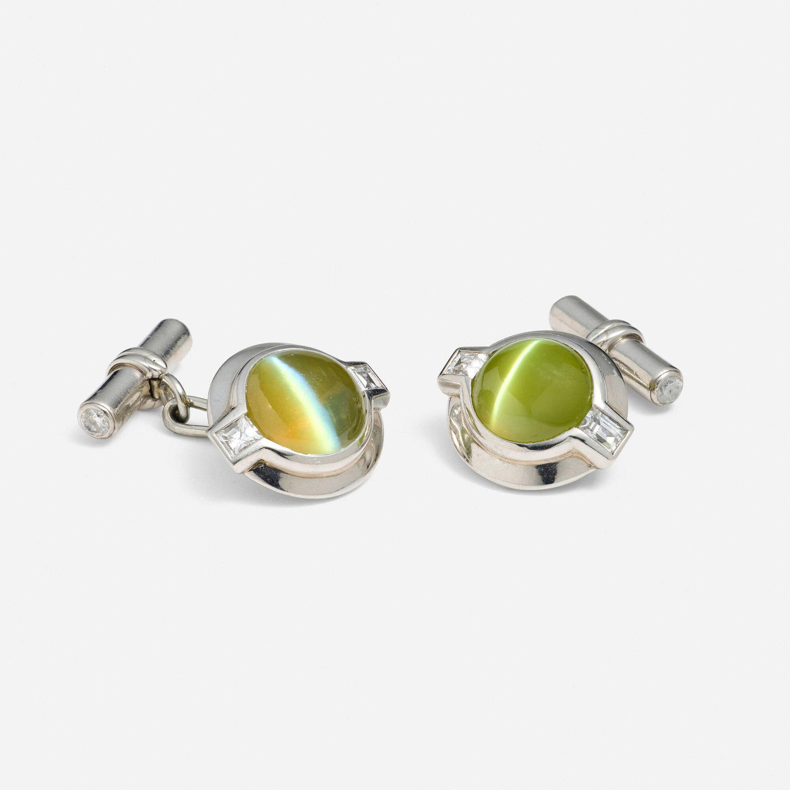Cat's eye chrysoberyl, diamond, and platinum cufflinks: Cat's eye chrysoberyl, diamond, and platinum cufflinks Each set with a cabochon cat's eye chrysoberyl, baguette and round brilliant-cut diamonds Platinum 0.875 x 0.50 in; Gross weight 9.1 dwts