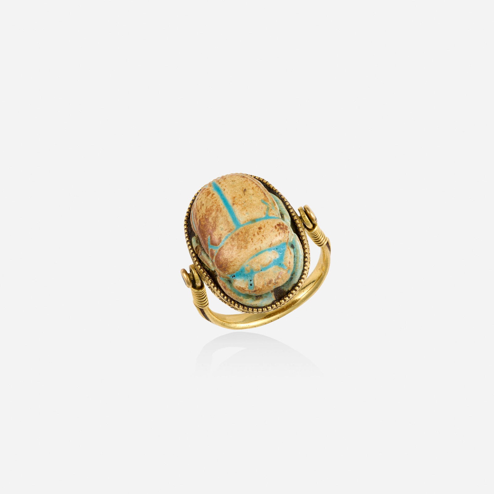 Egyptian Revival, Faience and gold scarab ring: Egyptian Revival Faience and gold scarab ring Set with a carved faience scarab Yellow gold Ring size approx. 5; Gross weight 3.1 dwts This work will ship from Lambertville, New Jersey.